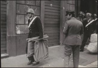 Italian police having forcibly evicted squatters, carry away their belongings