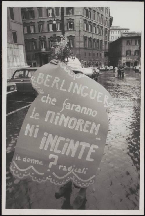 A member of the Radical party carries a protest placard that criticises the politician Enrico Berlinguer's approach to the abortion law