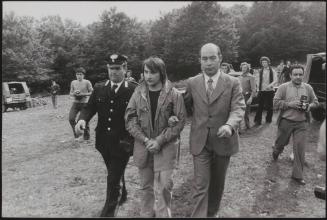 Policemen lead away Alessandro D'Intino in handcuffs in the aftermath of a gun battle with neo-fascists on L' Rascino Plateau in which right-wing extremist Giancarlo Esposti was shot dead