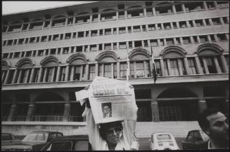 A woman holds a newspaper with the headline 'Victory for DC (Christian Democratic Party)'/'Change in Liberty', standing in the Piazza don Sturzo, Rome