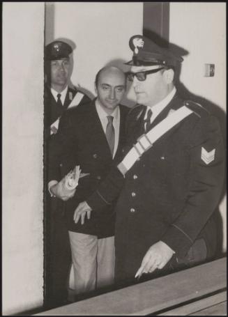 The murderer Marino Vulcano being led into the dock by police