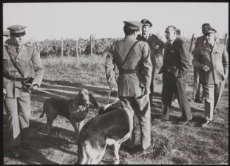 Group of policemen, sniffer dogs and police commissioner during the hunt for plane-jacker Raphael Minichielli