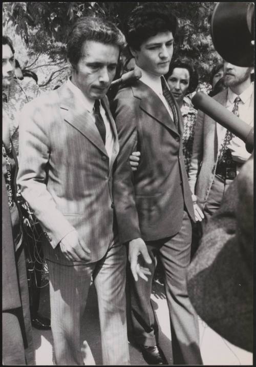 Plane-jacker Rahael Minichiello is led through clamouring press and passers-by outside court by one of his Italian lawyers, Edmondo Zappacosta