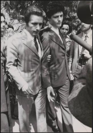 Plane-jacker Rahael Minichiello is led through clamouring press and passers-by outside court by one of his Italian lawyers, Edmondo Zappacosta