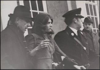 A young demonstrator or journalist is led away by Italian police in Italian parliament after she disrupted the visit by British prime minister Harold Macmillan