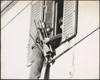 Soldiers climbing out of a window having collected weapons from inside