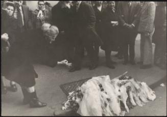 A woman grieves at the site of a shooting on Via Ferrucio