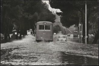 A bus drives through flood waters