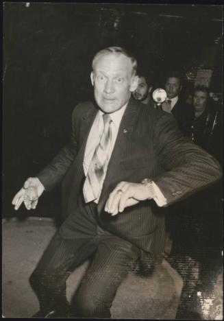 American Astronaut Buzz Aldrin lunges at the the paparazzi photographers outside the Number One Club, Rome, 1971
