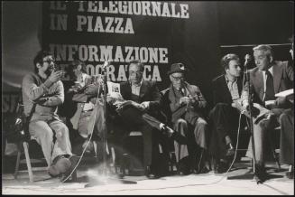 From left Preco, Camillus Benevento, Roberto Calvi, Terracini, Gabriele Isman and Annibale Paloscia, on a stage, behind them a banner reads 'The news in the square - democratic information'