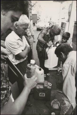 People collecting petrol in containers during a petrol station strike.
