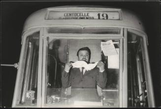 A man at the front of a hijacked bus removes the handkerchief masking his face