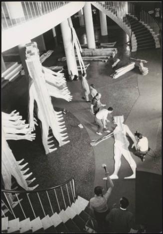 At Palazzo del Cinema di Venezia in Lido di Venezia, workmen and technicians put together a large sculpture by Mario Ceroli