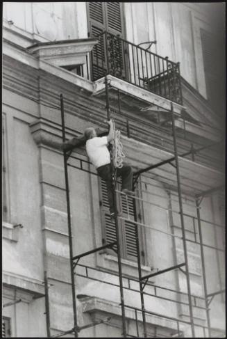 A construction worker climbs scaffolding