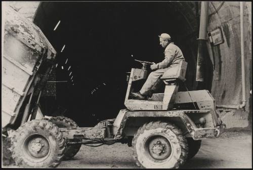 A man drives a tipper truck. 