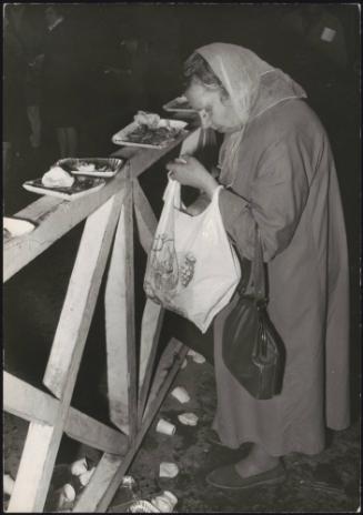 Inscribed 'Misery'.  A poverty stricken woman collecting left over food from mostly eaten street vendour plates. Messina.