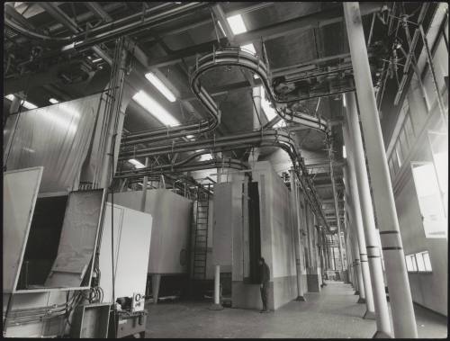 View of a factory interior showing tubes and sliding panels for painting products