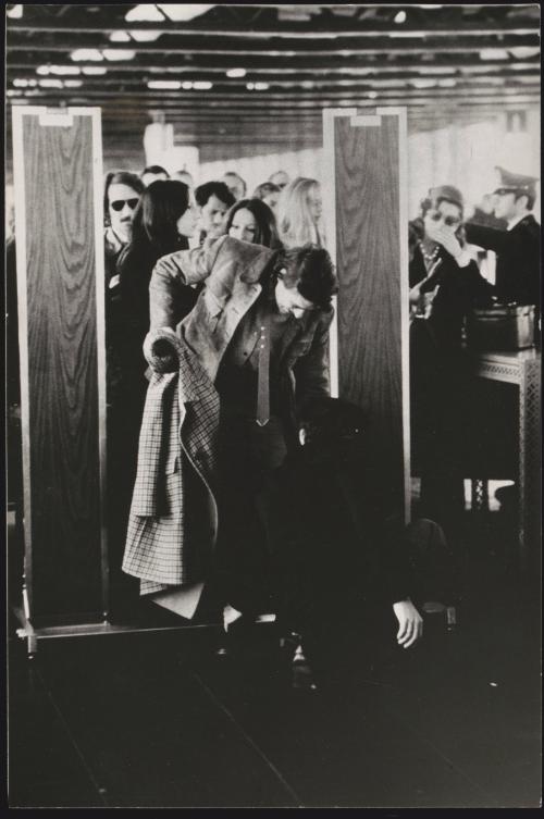 A security guard checks a passengers shoes as they go through a security gate at the airport