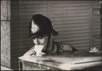 A firefighter moving a large chest out of a building damaged by the Belice earthquake, Sicily 1968