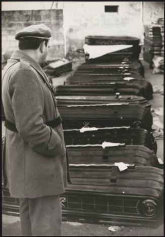 Sicilian man looks over rows of coffins containing victims from the Belice earthquake, 1968