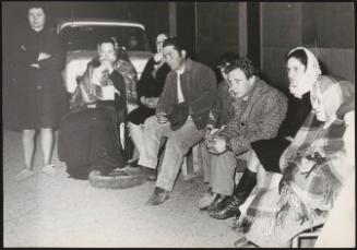 Survivors and refugees of the Belice earthquake sit out on the street at night