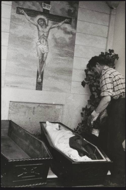 A man prepares a body in a coffin for burial in the Osoppo cemetery after the Friuli earthquake claimed 939 lives