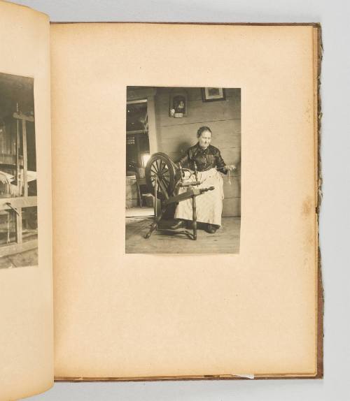 [Elderly woman checks her work at the spinning wheel] [Page 46 of Quebec I; from collection of Canadian albums compiled by Edith S. Watson, 1890s-1930s.]