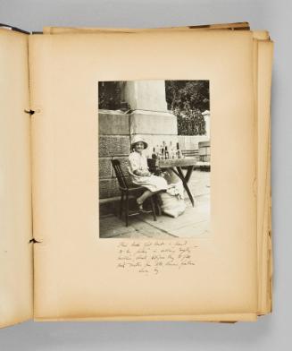 This little girl lends a hand to her father in selling empty bottles, which pilgrims buy to fill with water from Ste. Anne's fountain near by. Page 17 of Ste Anne de Beaupré; from collection of Canadian albums compiled by Edith S. Watson, 1890s-1930s