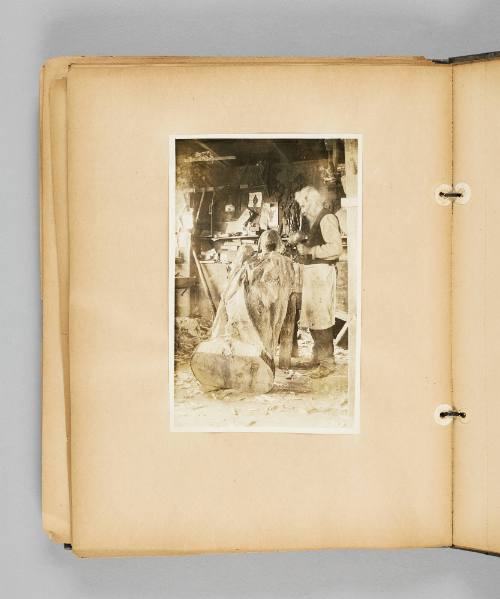 [Carver Louis Jobin chisels away at a large wooden religious statue] Page 64 of Ste Anne de Beaupré; from collection of Canadian albums compiled by Edith S. Watson, 1890s-1930s