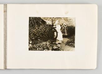 [Woman sitting at spinning wheel in lush garden, page 33 of The Doukhobors I album