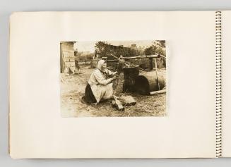 [Woman in headscarf squatting and holding bundle of straw, page 30 of The Doukhobors I album