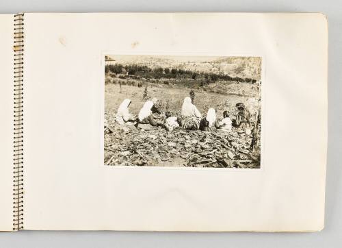 [Women and children sitting on farmland with backs turned, page 23 of The Doukhobors I album]
