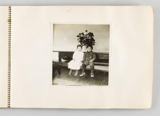 [Boy and girl sitting on bench in front of planter, page 13 of The Doukhobors I album]