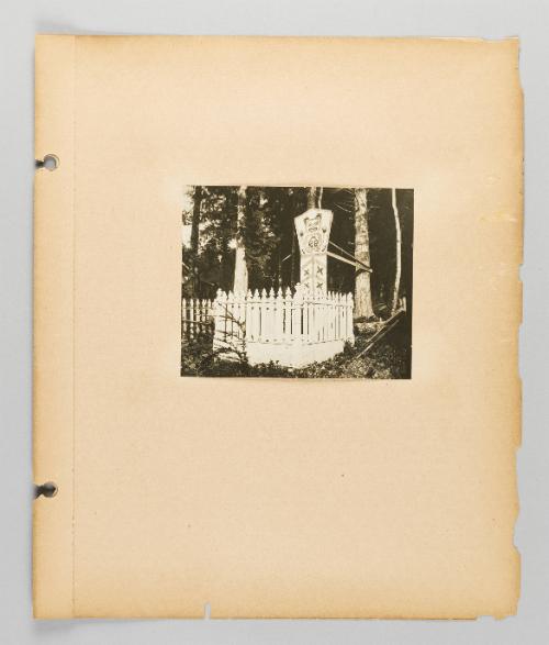[Grave marker with bear surrounded by white fencing, page 19 of Alert Bay, Queen Charlotte Islands, and Victoria, B.C. album]