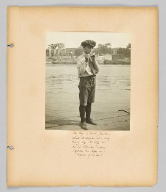 The boys of rural Quebec start to smoke at a very early age. This little lad on the Richilieu is seen lighting his pipe as a matter of course! [Page 45 of Children album]
