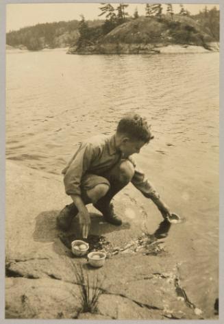 "Grimel Jr." all the way from Barcelona Spain, cooks the eggs for our lunch in the French river, Canada, + thinks he is having a holiday worth while.
