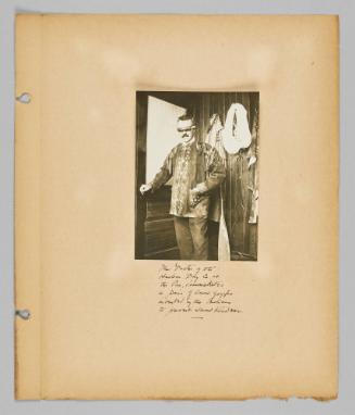 The Doctor of the Hudson Bay Co. at the Pas. demonstrates a pair of sand goggles invented by the Indians to prevent snow blindness [Page 49 of New Canadians album]
