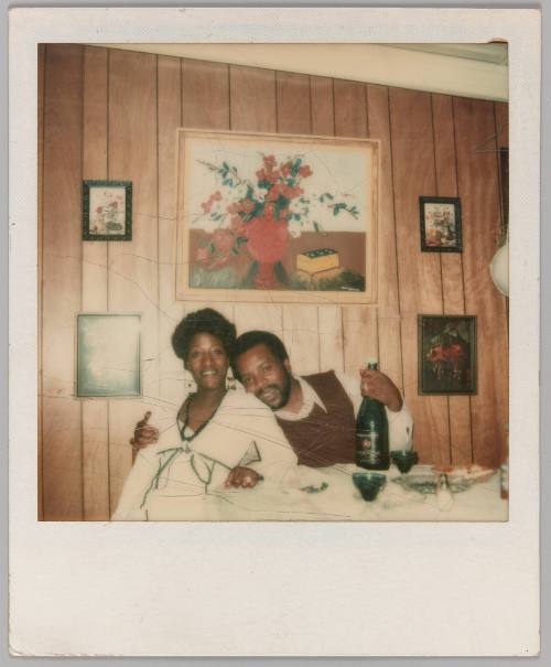 Our Mothers, 11-25-17 [Man and woman sitting in front of wood panelled wall, painting of red flower in background]