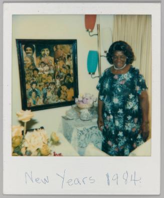 New Years 1984 [Woman in black floral dress looking down and smiling, framed collage work hanging on wall]
