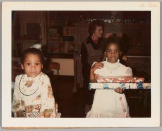 Xmas Party, 12/20/74, Ronzi & Pam [Two little girls holding christmas presents]