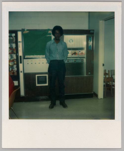 [Man standing in front of vending machines]
