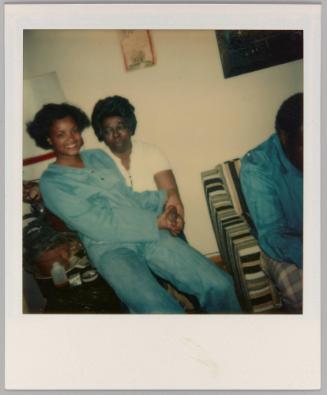 [Woman sitting on man's lap holding hands and smiling]
