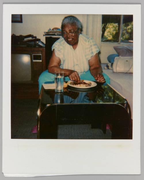 [Woman eating meal with glass of water on table]
