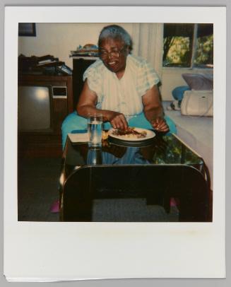 [Woman eating meal with glass of water on table]

