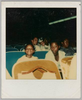 [Girl and boy sitting in auditoriam seats]
