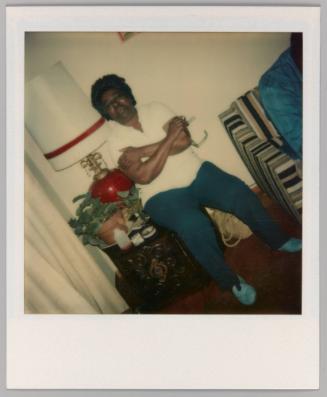 [Man sitting on side table with arms crossed and closed eyes]
