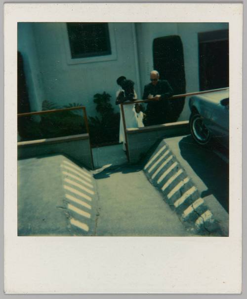 [Parking lot with man and woman in background]
