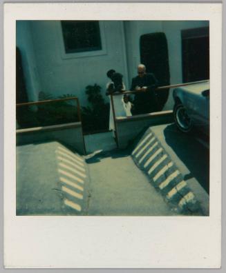 [Parking lot with man and woman in background]
