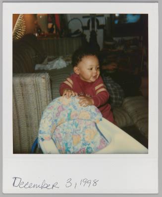 December 3, 1998 [Toddler pulling himself up using booster seat]