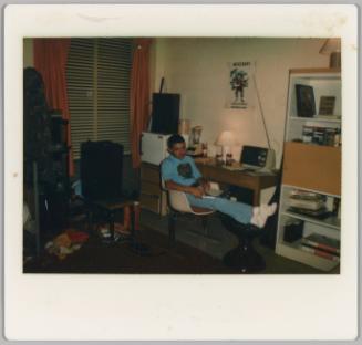 [Teenage boy writing on notepad at desk]
